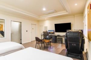 仁川市Carlton Hotel的酒店客房设有一张床和一张带电视的书桌。