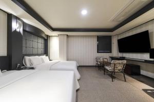仁川市Carlton Hotel的酒店客房设有两张床和一台平面电视。