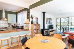 肯图巴Katoomba Falls Cottage的厨房以及带桌椅的起居室。