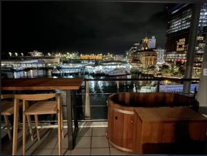 奥克兰Luxury Apartment - Parking - Hot Tub - Stunning Views的酒吧,晚上可欣赏到城市景观