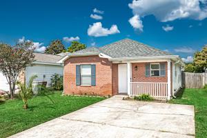 纳瓦拉Surfside Cottage near Navarre Beach的砖屋,有院子