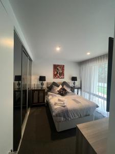墨尔本Ruckers Hill Northcote Penthouse的一间卧室设有一张床和一个大窗户