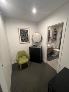 墨尔本Ruckers Hill Northcote Penthouse的浴室设有绿色椅子和镜子
