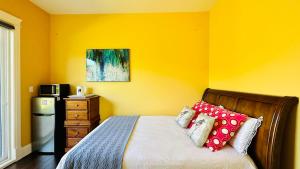 里士满Quiet Room in Richmond的黄色卧室配有红色枕头的床