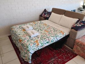 堪培拉Tuggeranong Short Stay #07C - Sleeps 6的一张床上床,床上有毯子,沙发上