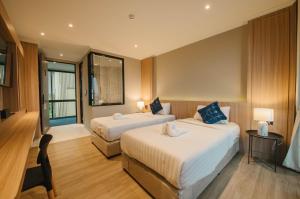合艾Carrara Hotel Hatyai的酒店客房设有两张床和窗户。