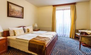 佩奇Sándor Hotel的一间卧室设有一张大床和一个窗户。
