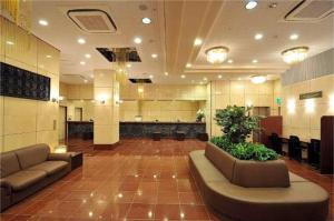 冈山Okayama Universal Hotel Annex 2的大厅,在大楼里长沙发和植物