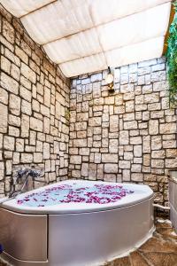 东京Petit Bali Ikebukuro的石头墙前的浴缸里装有鲜花