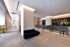 名古屋Vessel Hotel Campana Nagoya的大楼内带柜台和椅子的大堂