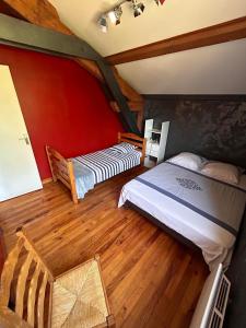Bas-en-BassetChambres des arrys的配有红色墙壁和木地板的客房内的两张床