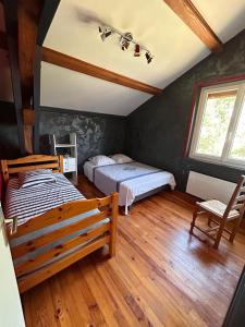 Bas-en-BassetChambres des arrys的一间卧室设有两张床,铺有木地板