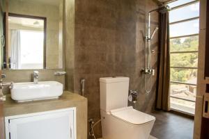 康提Kurumbunkz的浴室配有卫生间、盥洗盆和淋浴。