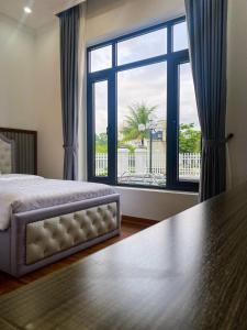 下龙湾Phượng Hoàng villa的一间卧室设有一张床和一个大窗户
