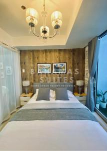 马尼拉The Bahamas and Maldives Suites at Azure Residences near Manila Airport的一间卧室配有一张大床和一个吊灯。