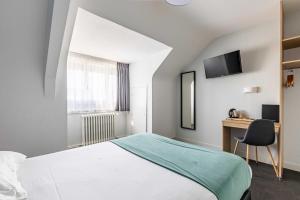 雷恩le paris brest hotel的配有一张床和一张书桌的酒店客房
