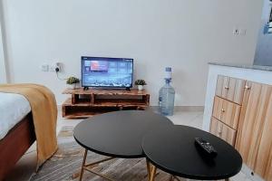 RuiruPremier Stays Ruiru的客厅配有桌子和电视