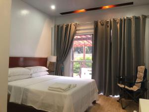 桑坦德Melbas Homestyle Resort & SPA的一间卧室配有床和带窗帘的窗户
