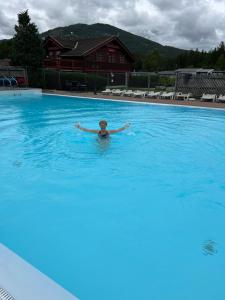 伯First Camp Bø - Telemark的在大型游泳池游泳的人