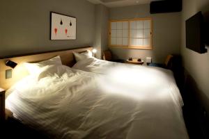 高松ALPHABED INN Takamatsuekimae的一间卧室配有一张白色的床,光线充足