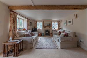 斯特劳德Traditional Cotswold Stone Peaceful Cottage with stunning views的客厅配有两张沙发和一张桌子