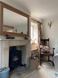 斯特劳德Traditional Cotswold Stone Peaceful Cottage with stunning views的客厅设有壁炉和镜子