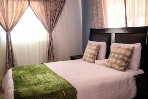 卡萨内Yaxida's Warmth的卧室配有带枕头的床铺和窗户。