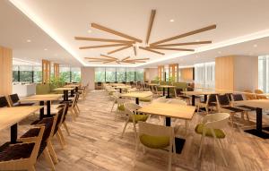 札幌Hotel Emion Sapporo的餐厅设有木桌和椅子以及大型天花板。