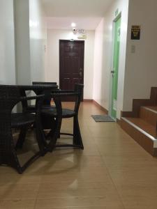 班塔延岛Marion's Inn Bldg 2 Bantayan powered by Cocotel的走廊上设有两把黑色椅子和一扇门