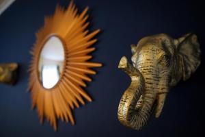 伦敦Enfield North London 3BR Apartment的一面镜子和一面墙旁边的象头