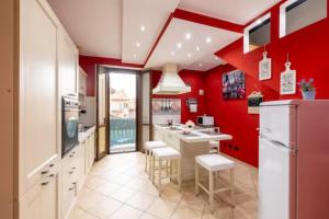 塞斯托卡伦德[Leonardo Academy in 5'] MXP, Laghi & Wi-Fi的厨房设有红色的墙壁和白色的橱柜