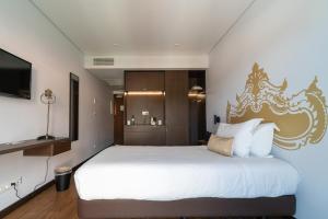 英雄港Palacio Santa Catarina Hotel的一间卧室配有一张白色大床和金色床头板