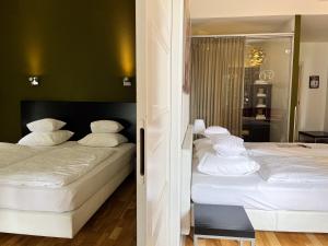 多廷赫姆鲁因兹赫别墅酒店的客房内的两张床和白色枕头