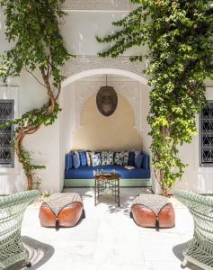 马拉喀什里亚德伊德拉酒店的绿树成荫的房间里一张蓝色的沙发