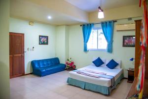 恰洛克拉姆VIVA ( on the beach )的一间卧室配有一张床和一张蓝色的沙发