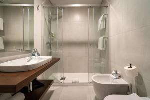 英雄港Palacio Santa Catarina Hotel的带淋浴、盥洗盆和卫生间的浴室