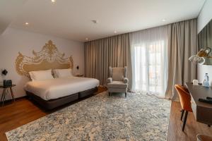 英雄港Palacio Santa Catarina Hotel的一间卧室配有一张特大号床和一把椅子