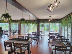 Ban Bang Kra叻丕府塔拉Spa度假村的用餐室设有桌椅和窗户。