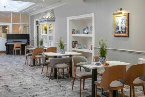 伊尔克利The Craiglands Hotel Sure Hotel Collection by Best Western的一间带桌椅和钢琴的用餐室