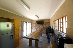 KareedouwSoloko Game farm的厨房配有木桌和冰箱。