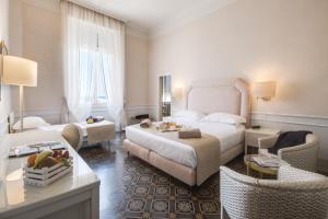维亚雷焦Grand Hotel Royal的酒店客房设有一间带一张床和椅子的卧室