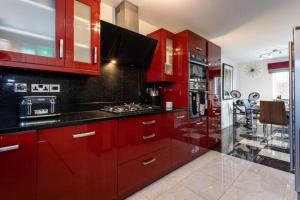 曼彻斯特Beautifully designed 3 Bed House - in Manchester的一间厨房,配有红色橱柜和台面