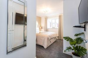 曼彻斯特Beautifully designed 3 Bed House - in Manchester的卧室两张图片,配有一张床和镜子