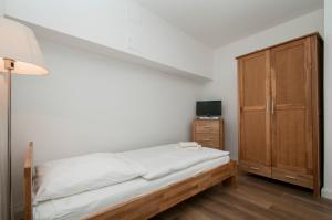 汉堡Appartements in der historischen Deichstrasse contactless Check in的一间卧室配有一张床和一个木制橱柜