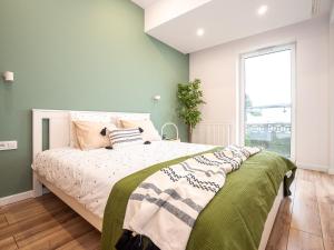 达布罗瓦古尔尼恰OAK TREE Apartment的一间卧室设有一张带绿色墙壁和窗户的床。