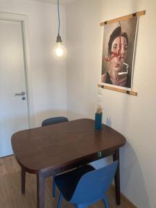 里斯河畔比伯拉赫Außergewöhnliches Apartment in bester Lage的一张带两张蓝色椅子的餐桌和一幅画