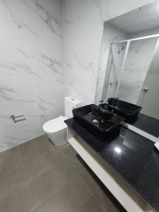 南迪Vualiku Hotel & Apartments的一间带黑色水槽和卫生间的浴室
