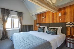 埃文河畔布拉德福蒂姆贝尔斯亚德宾馆的一间卧室配有一张带木墙的大床