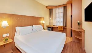 瓦伦西亚NH瓦伦西亚科学酒店的卧室配有一张白色大床和电视。