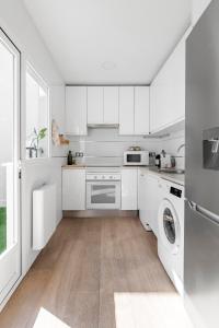 马德里Cozy 2 bedroom apartment with patio的厨房配有白色橱柜、洗衣机和烘干机